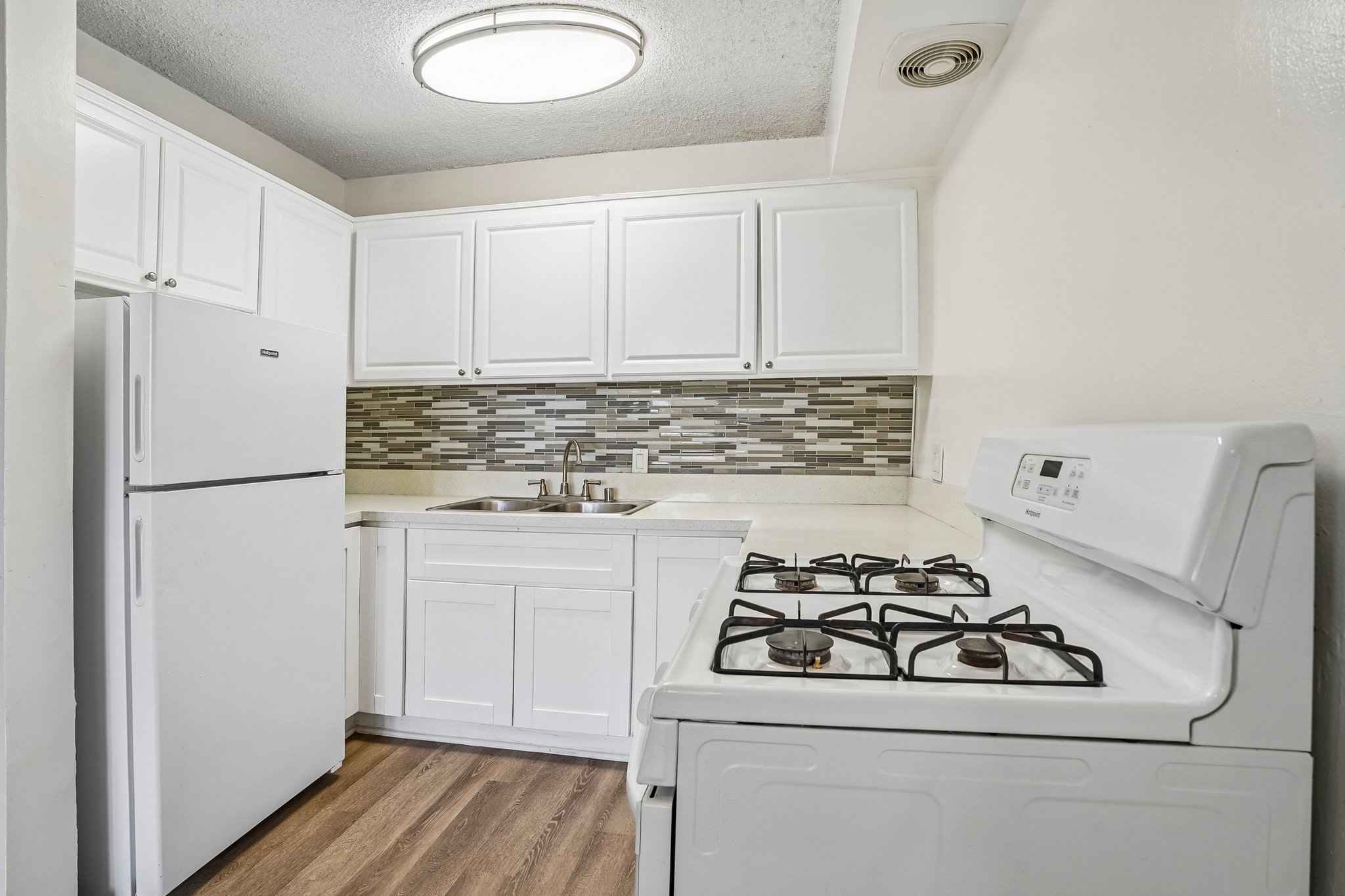 kitchen white cabinets tile backsplash at Terraces