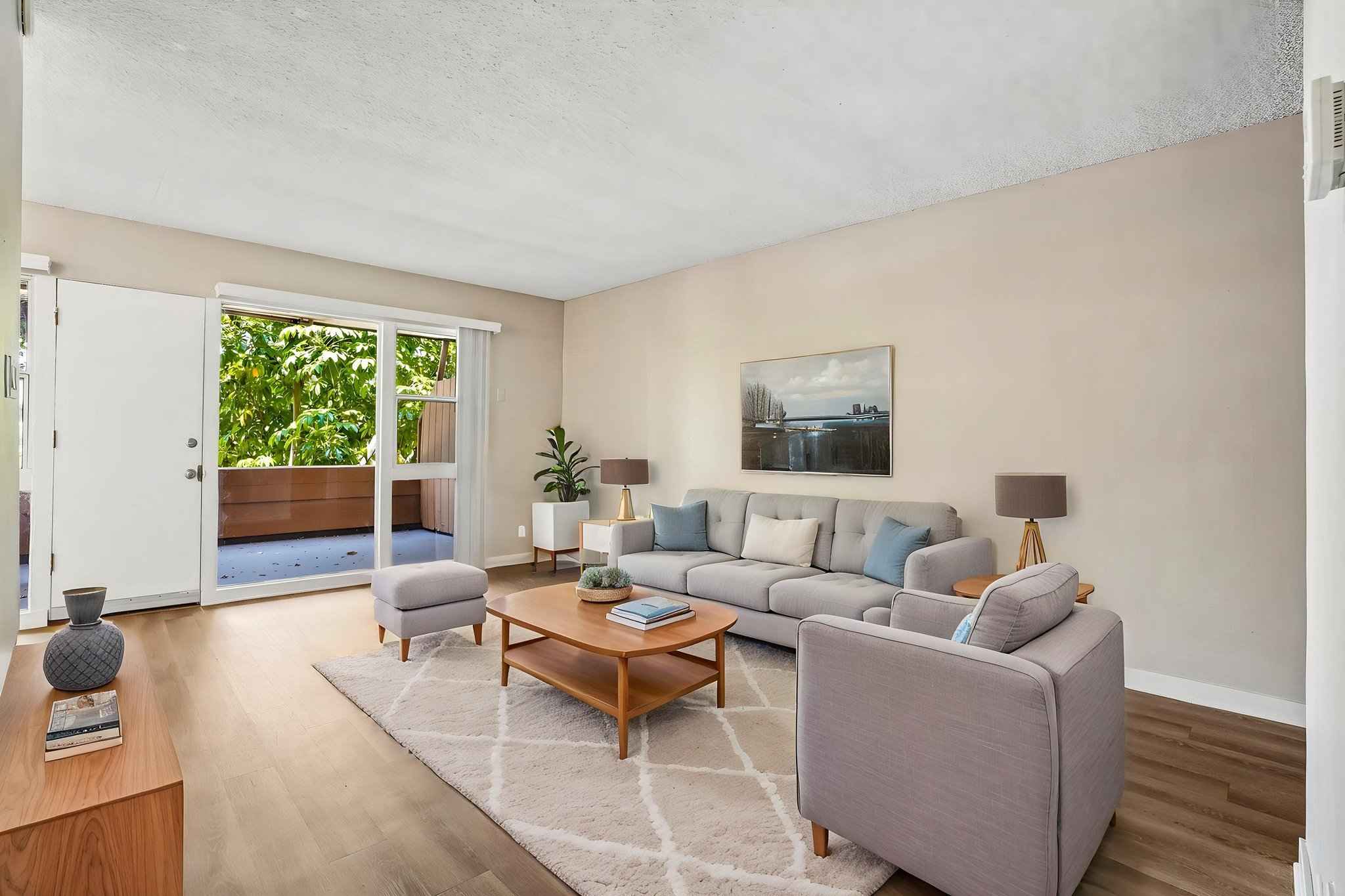 Virtually staged living room with wood floors and patio access at Terraces at South Pasadena